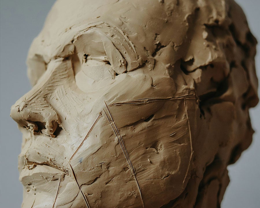 Someone rolling out clay on a board in a clay handbuilding class